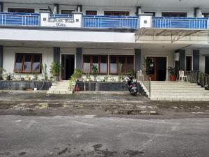 ein Motorrad, das vor einem Gebäude geparkt ist in der Unterkunft SPOT ON 92782 Rumah Kost Kita Tarakan in Tarakan