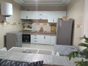 a kitchen with white cabinets and a stainless steel refrigerator at Tranquil Oasis in the Heart of Ifrane in Ifrane