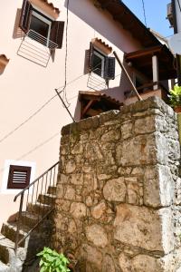 a building with windows and a stone wall at Apartments Dolores Old Town in Mošćenička Draga