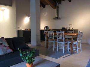 een woonkamer met een bank en een tafel en stoelen bij Al Borgo Appartamento in Venzone