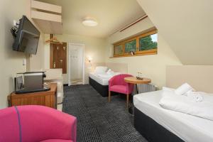 a hotel room with two beds and a tv at Hotel Premier- Adults Only in Bedřichov