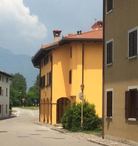 een geel gebouw aan de straatkant bij Al Borgo Appartamento in Venzone
