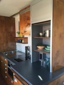 una cocina con encimera negra y fregadero en Tiny House im Seecontainer mit Parkplatz, Glasfaser, Netflix, Veranda und gehobener Ausstattung en Coburg