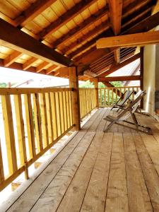 a wooden deck with two chairs sitting on it at Le chalet à comté in Saffloz