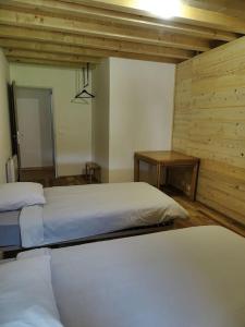 a bedroom with two beds and a mirror at Le chalet à comté in Saffloz
