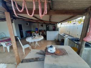 Zimmer mit einem Tisch und einer Küche mit einem Tisch in der Unterkunft Casa de campo in Barra do Garças