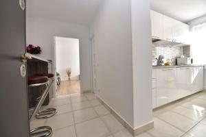 a kitchen with white cabinets and a white floor at Luxury Studio / M Romancierilor in Bucharest