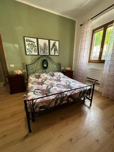 een slaapkamer met een bed met een bloemenbed bij Affittacamere La Rondinella in Montemerano