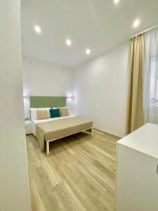 Habitación blanca con cama y ventana en Novalis Rooms, en Porto Cesareo