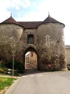 an old stone building with an archway at Studio avec une cour. in Joigny