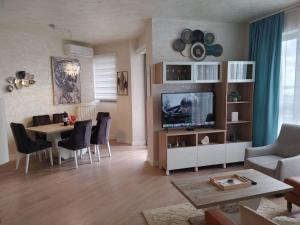 a living room with a television and a dining room at GIGI Apartment in Belgrade