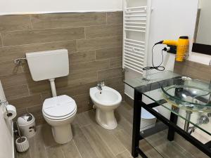 een badkamer met een toilet en een glazen wastafel bij Sergio’s home in Vittoria