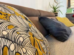- un oreiller sur un canapé avec une couverture colorée dans l'établissement Appartement T2 de vacances St Gilles les Bains   , à Saint-Gilles les Bains