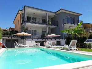 a villa with a swimming pool in front of a house at Appartamenti da Mirella in Lazise