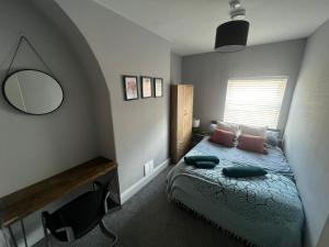1 dormitorio con cama con espejo y ventana en The Terrace Chester, modern 3 bed house en Chester
