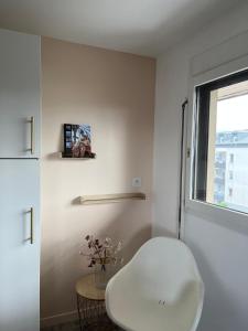 uma cadeira branca num quarto com uma janela em Golden Dreamscape - Superbe, calme et lumineux em Thonon-les-Bains