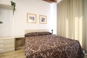 1 dormitorio con 1 cama en una habitación blanca en Espinach Port Serrallo, en Tarragona