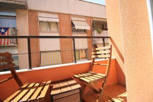 einen Stuhl auf einem Balkon mit einem Gebäude in der Unterkunft Espinach Port Serrallo in Tarragona