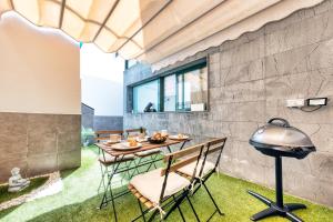 un patio avec une table, des chaises et un grill dans l'établissement Casa Costa Esmeralda-shared pool, à Costa Teguise