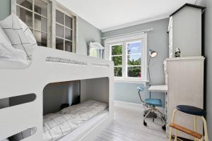 ein Schlafzimmer mit einem Etagenbett, einem Schreibtisch und einem Stuhl in der Unterkunft Leilighet på Smestad in Oslo