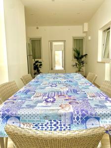 una mesa con un edredón azul y blanco en Novalis Rooms, en Porto Cesareo