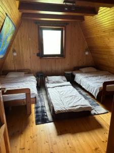 um quarto no sótão com 3 camas e uma janela em Dom na Kaszubach Sulęczyno z widokiem na jezioro em Suleczyno