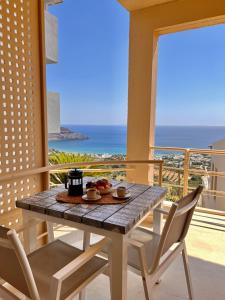 a table and chairs on a balcony with a view of the ocean at Stella in the Village Studio Sea View in Plakias