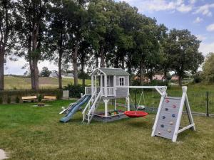 a playground with a slide and a play house at Słoneczny domek in Kretowiny