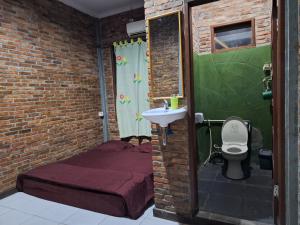 a bathroom with a bed and a sink and a toilet at Bua Guest House in Medan