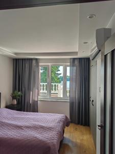 a bedroom with a large bed and two windows at Apartament nad jeziorem Sport i Rekreacja in Ełk