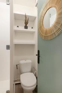 een badkamer met een wit toilet en een spiegel bij Le chevremont in Metz