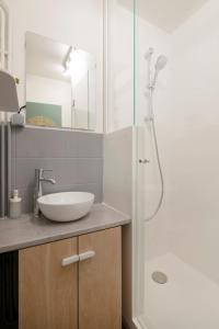 een badkamer met een wastafel en een douche bij Le chevremont in Metz