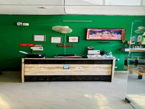 una pared verde con un mostrador en una tienda en OYO Flagship 12976 Hotel New Fiza, en Jammu