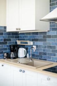 uma cozinha com um lavatório e uma parede de azulejos azuis em Apartament Panoramika-Marina Dziwnów em Dziwnów