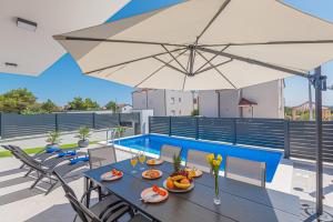 une table avec de la nourriture et un parasol sur le toit dans l'établissement Villa Katarina Vodice, à Vodice