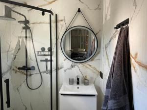 a bathroom with a sink and a mirror at Apartamenty Bonanza in Białogóra
