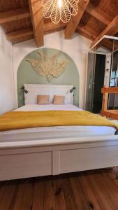 a bedroom with a large bed with a chandelier at maisonnette avec jardin et terrasse in Montdardier