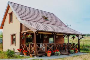 a house with a porch and a roof at Domek na skarpie in Szczybały Giżyckie