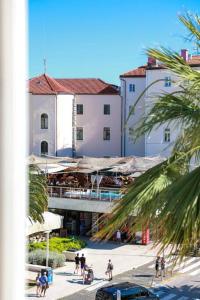 a group of people walking on a sidewalk in front of a building at Apartment Tonka-Riva in Split