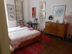 a bedroom with two beds and a dresser and a table at Mansion at Chora in Andros in Andros