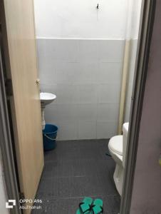 een badkamer met een toilet en een wastafel bij Homestay Saujana Harmoni D'Petron in Gua Musang
