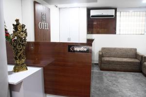 vestíbulo con recepción y sofá en Otel, en Nagpur