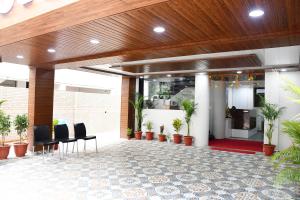 un hall avec des chaises et des plantes dans un bâtiment dans l'établissement Otel, à Nagpur