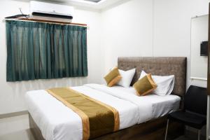 a bedroom with a bed with a television on top of it at Otel in Nagpur +16 photos