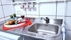 a kitchen sink with a plate of food and a glass of wine at City Suite - 5 Min to HBF in Mannheim