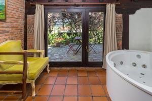 ein Badezimmer mit einer Badewanne und einem Stuhl in der Unterkunft La Posada de Langre Anexo in Langre