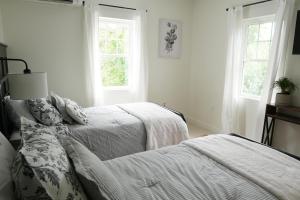 um quarto branco com 2 camas e 2 janelas em The Inn at Terra Farms em Glen Rock