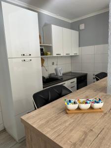 een keuken met een houten tafel met twee kommen erop bij STUDIO APARTMAN PAVIĆ in Vinkovci