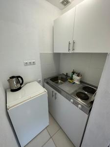 a small kitchen with a sink and a refrigerator at Vila Dzenana Boracko Jezero in Konjic