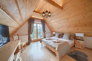 ein Schlafzimmer mit einem Bett und einer Holzdecke in der Unterkunft Rezydencja Pod Sadami in Szczawnica